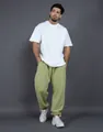 Male model wearing baggy light green fleece joggers with white t-shirt in studio - Matcha Green