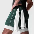 Detalle de los pantalones cortos deportivos verdes de doble capa con lazo para toalla. - Verde Oscuro