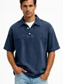Detailed view of a men's navy blue washed cotton short-sleeve polo shirt with white buttons. - Navy Blue