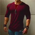 High-quality detail view of a slim fit men's long sleeve burgundy t-shirt with curved hem - S / Tops / Red