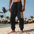 Detail view of men's charcoal cargo beach pants with contrast pockets on a sandy shore - S / Bottoms / Black