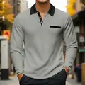 Detailed view of a men's grey waffle textured long-sleeved polo shirt with black collar. - S / Tops / Gray