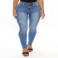 Detail view of women's blue high-waisted ripped skinny jeans with raw hem - S / Bottoms / Denim Blue