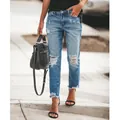Street style view of women's ripped straight-leg jeans with frayed hem details. - S / Bottoms / Denim Blue