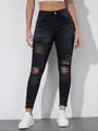 Detail of slim fit black ripped denim jeans showing distressed texture and holes - S / Bottoms / Black
