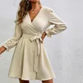 Close-up of elegant beige wrap dress with lantern sleeves and belted waist. - S / Off White