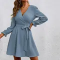 Detail of a light blue V-neck wrap dress with lantern sleeves and textured fabric. - S / Grey Blue