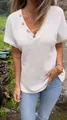 Close-up view of white waffle knit V-neck short sleeve top with wooden buttons. - White