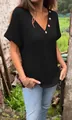 Close-up detail of women's black waffle knit T-shirt with V-neck and wood buttons. - Black