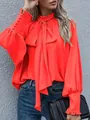 Elegante hellrote Satin-Bluse mit Stehkragen, Schluppe und Puffärmeln für Damen. - Orange