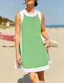 Close-up detail of a lime green and white sleeveless summer tunic worn on a sunny beach. - Green