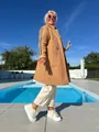 Donna elegante in cappotto di lana d'agnello cammello con strisce vicino a una piscina. - Taglia S / Top / Kaki