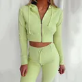 Primer plano de la textura acanalada de este conjunto deportivo slim verde neón con capucha - S / Top y Pantalones / Verde Frijol