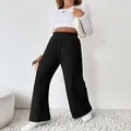 Detail view of black ribbed knit wide-leg pants with elastic high waist. - S / Bottoms / Black