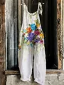 Close-up detail of white sleeveless wide-leg jumpsuit with artistic floral print - S / Pattern 5