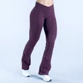 Detailed view of seamless yoga flare leggings with a cross-over high waist in deep purple. - XS / Bottoms / Fuschia