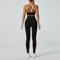 Back view of a black yoga set featuring a cross-back sports bra and high-waist leggings. - M / Top And Bottom / Black