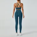 Professional two-piece teal yoga set with criss-cross back sports bra and high-waisted leggings - Dark Green