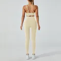 Women's beige yoga set featuring cross-strap sports bra and high-waisted leggings - Khaki