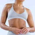 Detail of a light grey seamless sports bra with jacquard texture on the waistband. - Clay Gray