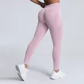 Pink seamless high-waisted yoga leggings featuring a flattering peach butt lift design. - Pink