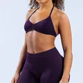 Close-up view of a deep purple seamless yoga set with halter neck sports bra on a model - Grape Purple