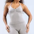 Detailansicht des Neckholder-Tops und der nahtlosen Leggings-Struktur des Yoga-Sets. - XS / Oberteile / Federbeige