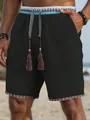 Detail van zwarte heren strandshort met etnisch borduursel en trekkoord met kwastjes - M / Bottoms / Zwart