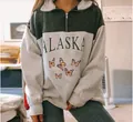 Close-up of Alaska and butterfly print detail on a two-tone oversized half-zip sweatshirt - Butterfly Green