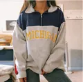 Detailed view of a women's color-block quarter-zip sweatshirt with Michigan text - Blue Letter Print