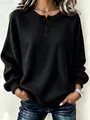 Gedetailleerd overzicht van de zwarte wafelbreistructuur en de knoop-henley-halslijn van de sweater - S / Tops / Zwart