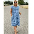 Detail of woman wearing blue Bohemian abstract print midi dress in outdoor resort setting. - S / Top And Bottom / Sky Blue