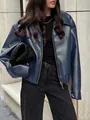 Primo piano di una giacca da motociclista in pelle blu indossata da una modella all'aperto - Blu zaffiro