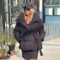 Stilvolle Frau in schwarzer Stehkragen-Pufferjacke mit Gürteltaille im Stadtbild - S / Oberteile / Schwarz