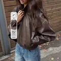 Vista dettagliata del bomber in pelle PU marrone con etichetta di materiale resistente - Taglia S / Top / Marrone scuro