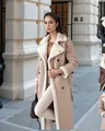 Eleganter beiger Damen-Lammfellmantel mit Reverskragen, getragen von einem Model in der Stadt - Aprikose