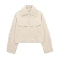 Detailansicht einer beigen Bouclé-Kurzjacke mit Reißverschluss und zwei großen Brusttaschen - XS / Oberteile / Beige