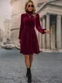 Full view of elegant burgundy velvet long sleeve dress worn by model on a city street. - S / Top And Bottom / Burgundy