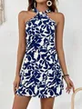 Detail view of the blue and white leaf print halter neck sleeveless mini dress on a model - S / Bottoms / Blue