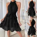 Elegante zwarte mouwloze halterjurk met gelaagde ruches en een modieuze strikceintuur - S / Boven- En Onderstuk / Zwart