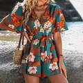 Close-up of tropical floral print romper with flutter sleeves and tie-waist detail. - S / Green