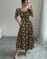 Détail d'une robe midi fleurie noire avec manches bouffantes et décolleté carré. - S / Haut Et Bas / Floral Jaune (Noir)