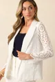 Detail van het elegante witte broderie anglaise op een getailleerde dames blazer - S / Tops / Wit
