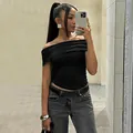 Stylish model wearing a black off-the-shoulder ruched cropped top for a slim fit look - Black