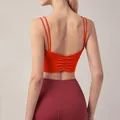 Close-up detail of the sexy ruched back design on an orange quick-dry gym sports bra - Orange