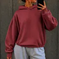 Close-up of a burgundy oversized hoodie with adjustable drawstring hem for a casual fit. - Burgundy