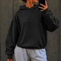 Oversized black hoodie with drawstring hem shown in a street-style mirror selfie - Black