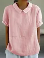 Close-up detail of the pink cotton blouse's collar and front texture on a model. - Pink