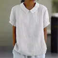 Close-up detail of women's white loose cotton short sleeve shirt with Peter Pan collar - S / Tops / White