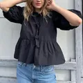 Elegante blusa negra con mangas abullonadas, lazos delanteros y un bajo de peplum mujer - S / Tops / Negro